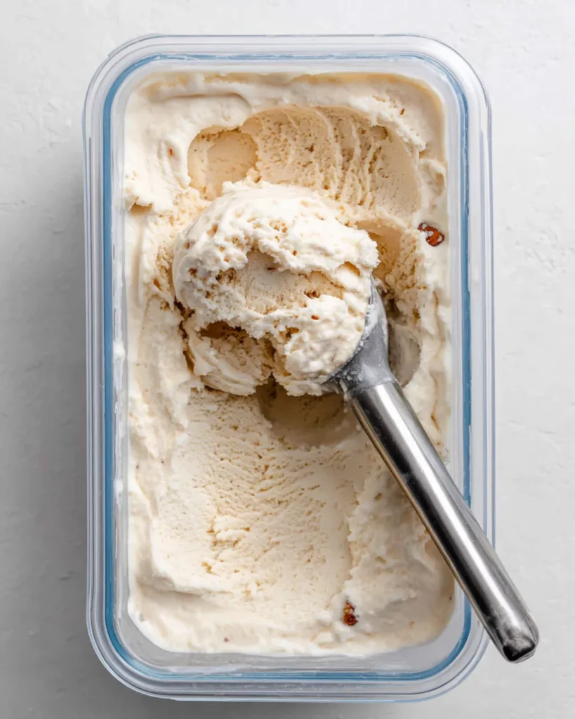 Freezer-safe airtight container of pecan ice cream with a scoop mark visible