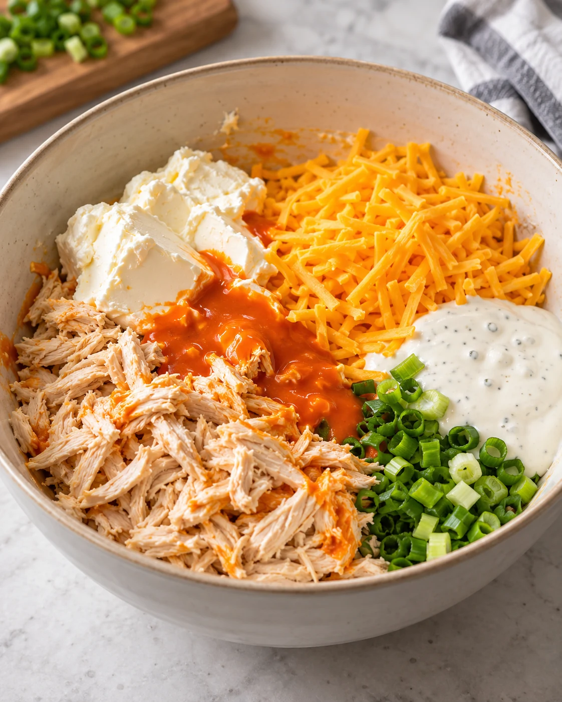 Buffalo ranch chicken filling ingredients combined in a mixing bowl