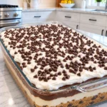Chocolate chip cookie pudding cake layered in a clear glass baking dish