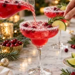 Christmas Mistletoe Margarita poured over ice and garnished with cranberries, rosemary, and lime