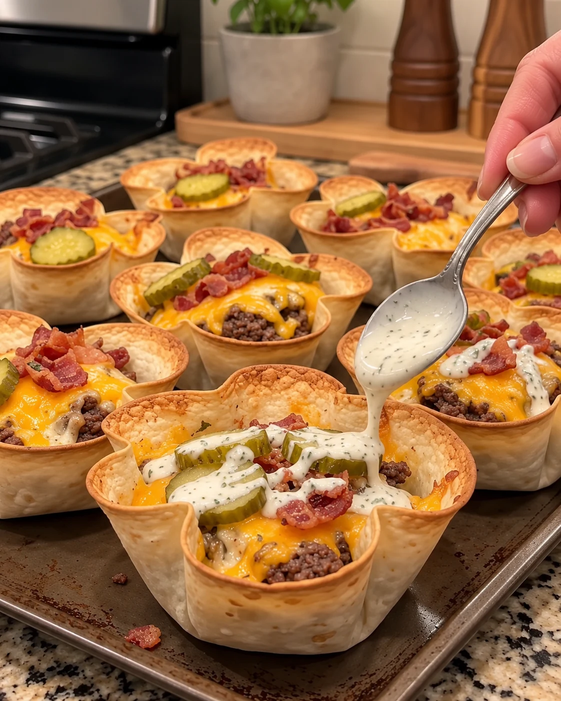 Finished cheeseburger taco cups topped with pickles and ranch
