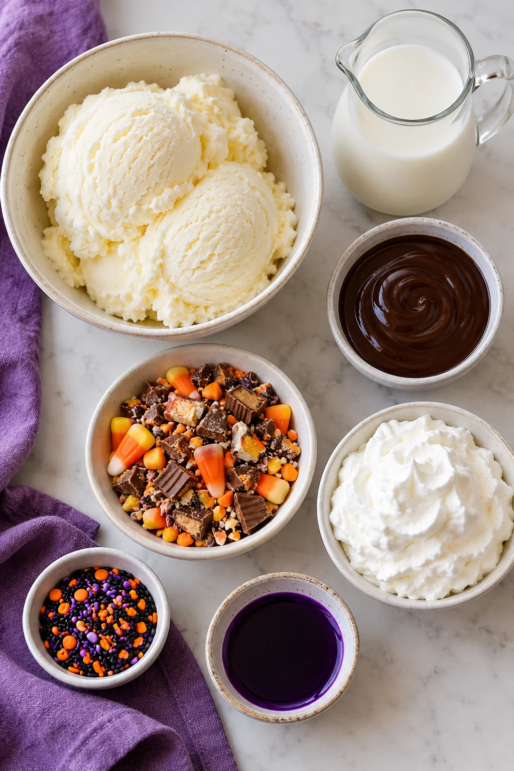 Vanilla ice cream, milk, chocolate syrup, Halloween candy, whipped cream, sprinkles, and purple syrup
