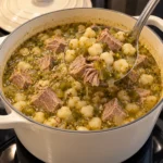 New Mexico pork and hominy stew with green chile broth in a cream Dutch oven