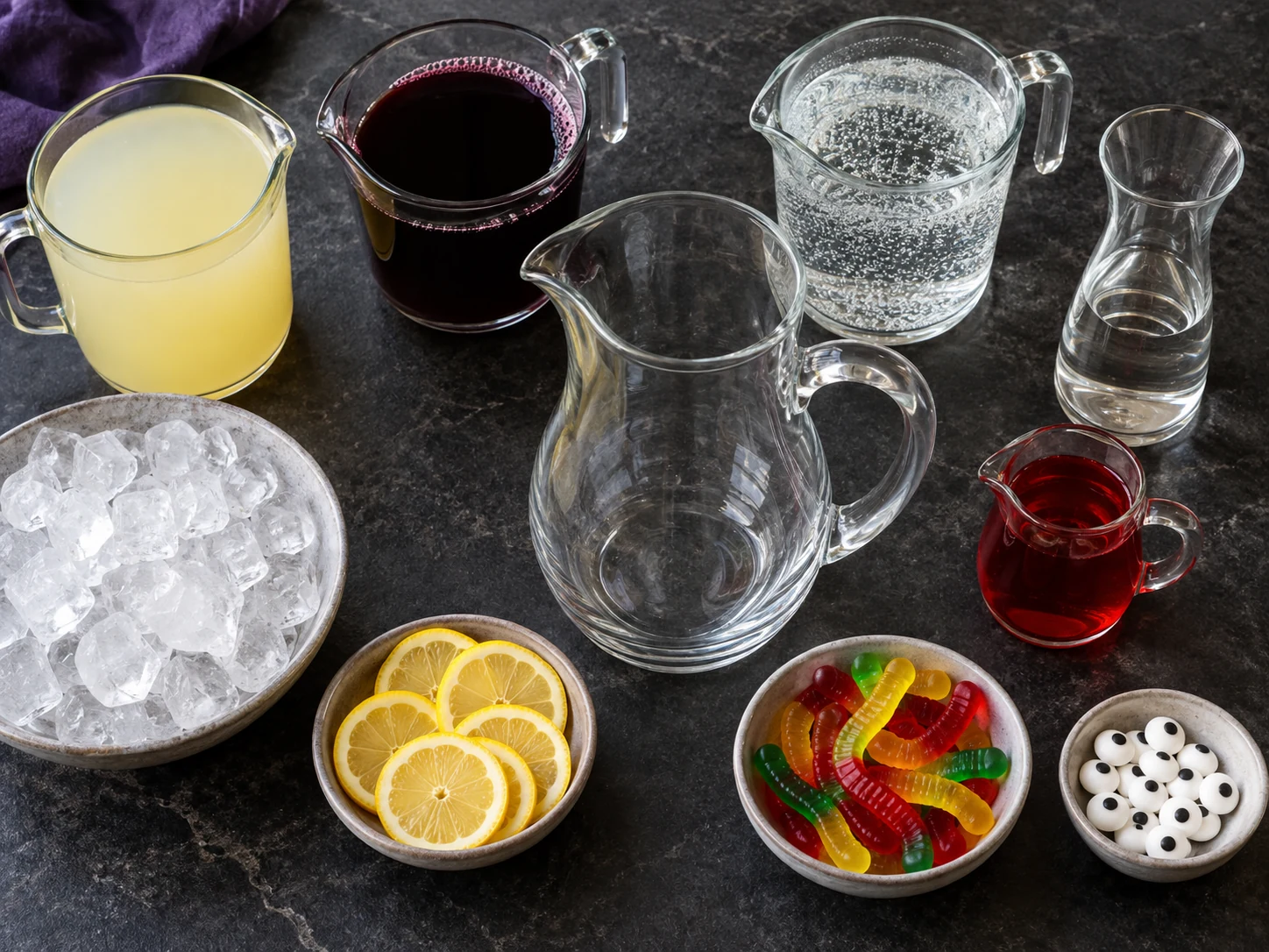 Lemonade, grape juice, lemon-lime soda, optional vodka, grenadine, ice, lemons, gummy worms, and candy eyes
